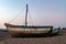 A lonely boat on the beach, sand.  late time of the day