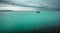 Lonely boat on turquoise water under dark sky