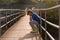 Lonely boy sitting on a suspension bridge