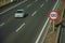 Lonely car on highway and SPEED LIMIT signpost in Madrid