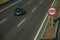 Lonely car on highway and SPEED LIMIT signpost in Madrid