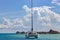 Lonely catamaran against the background on overwater bungalows stretching out across the lagoon in Bora Bora island