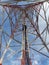 A lonely cellular network tower is seen against a clear blue sky. GPS, 3G, 4G, 5G signal receiver and transmitter.