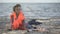 Lonely child refugee in lifejacket sitting shore, dangerous migration across sea
