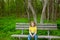 Lonely children girl happy sitting on park bench