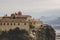 Lonely Christian monastery building landmark on top of rock dramatic scenic mountain environment in autumn cloudy season weather,