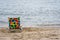 Lonely colorful chair on the beach near the ocean