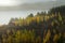 Lonely cottage surrounding by yellow tree in Autumn season with sea and mountain range background