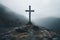 lonely cross on a rock in a foggy gloomy mountain landscape