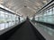 Lonely cute child travelling on travelator at airport terminal