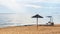 Lonely deck chair, beach umbrella and path to sea on deserted beach near Kavala, Greece. Calming seascape. Copy space