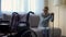Lonely disabled woman sitting on sofa and looking at empty wheelchair, memories