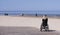 Lonely disabled young woman on beach. Sunny summer day