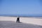 Lonely disabled young woman on beach. Sunny summer day