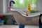 Lonely doll toy drowning in the water in the bathroom, children, danger, hand