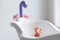 Lonely doll toy drowning in the water in the bathroom, children, danger, hand