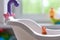 Lonely doll toy drowning in the water in the bathroom, children, danger, hand