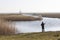 Lonely fisher with fishong rod in dutch landscape