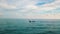 Lonely fishing boat drifting on sea waves. Boat floating in ocean on cloudy sky