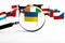 Lonely flag of ukraine through a magnifying glass on the background of the flags of the european union