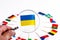 Lonely flag of ukraine through a magnifying glass on the background of the flags of the european union. The concept of assistance