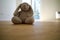 A lonely fluffy bunny sits on parquet floor