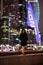 Lonely girl on the background of glowing skyscrapers