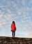 Lonely girl in red with cloudy blue sky and belgrade old fortress, serbia