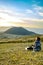 Lonely girl sitting next to Komezuka of Mount Aso Aso-san