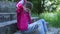 Lonely girl sitting on old stairs in the park