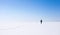 Lonely girl walks along the endless snowfield