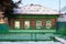 Lonely green log cabin stands in the winter.