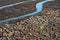 Lonely green sprout in dry cracked ground. Green plant growing through cracks in the ground, nature fighting the heat. Drought,