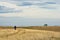 Lonely hiker is walking through flat prarie terrain