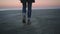 Lonely hipster, sailor man walking toward the sea at sunrise