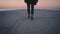 Lonely hipster, sailor man walking toward the sea at sunrise