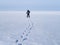 Lonely human walk by snow desert.