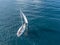 Lonely isolated yacht under the sail with tall mast going in still sea aerial top view Ð¼