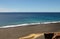 Lonely lifeguard chair on black sand beach