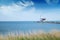 Lonely lighthouse stands on the spit in the sea near the village