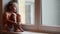 Lonely little boy waits for his parents to come home sitting on the windowsill