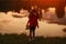 Lonely little girl standing on shore of lake