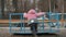 Lonely little kid girl spinning on a carousel at children`s playground
