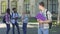 Lonely male student looking at happy laughing classmates standing near college