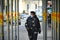 Lonely male teenager walk downtown wearing mandatory protective mask