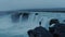 Lonely man at epic icelandic waterfall at dusk