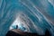 Lonely man in large ice cave in snow journey.
