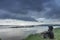 A lonely man on the river bank. Overcast. Landscape. River.