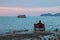 Lonely man sits on a bench on the coast looking at the sea. Travel.