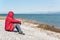 Lonely man sitting on the lakeshore, admiring the nature. Unrecognisable person